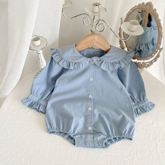Toddler blue long-sleeve romper with ruffled collar and cuffs on wooden hanger, vintage candlestick and ornate mirror in background