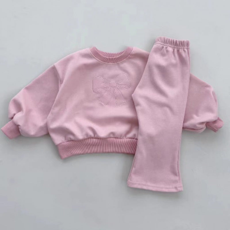 Toddler pink sweatshirt with embossed bow and matching pink pants laid flat on white surface